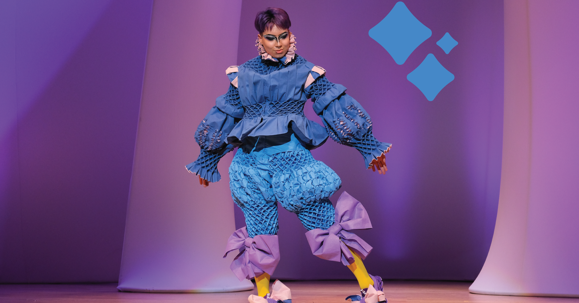 A model showcases an elaborate costume made from blue wrap—the recycled material used in the medical field