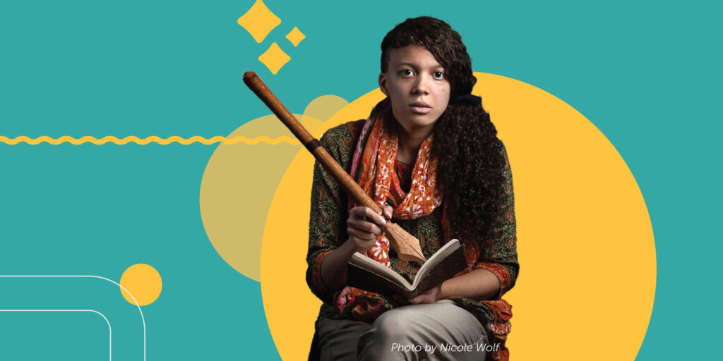 Maya Williams pretends to write with a giant pen, a ceremonial item traditionally passed from Portland Poet Laureate to the next