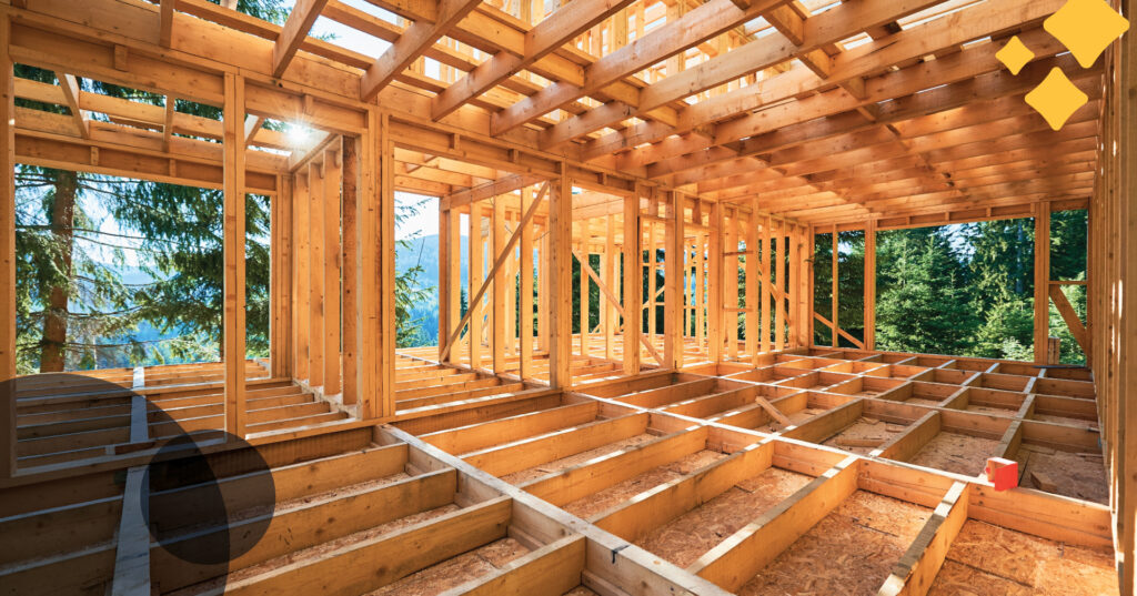 the framing for a house goes up in the middle of a forested property